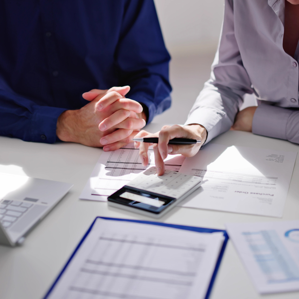 Reviewing accounting data on a keyboard and financial sheets
